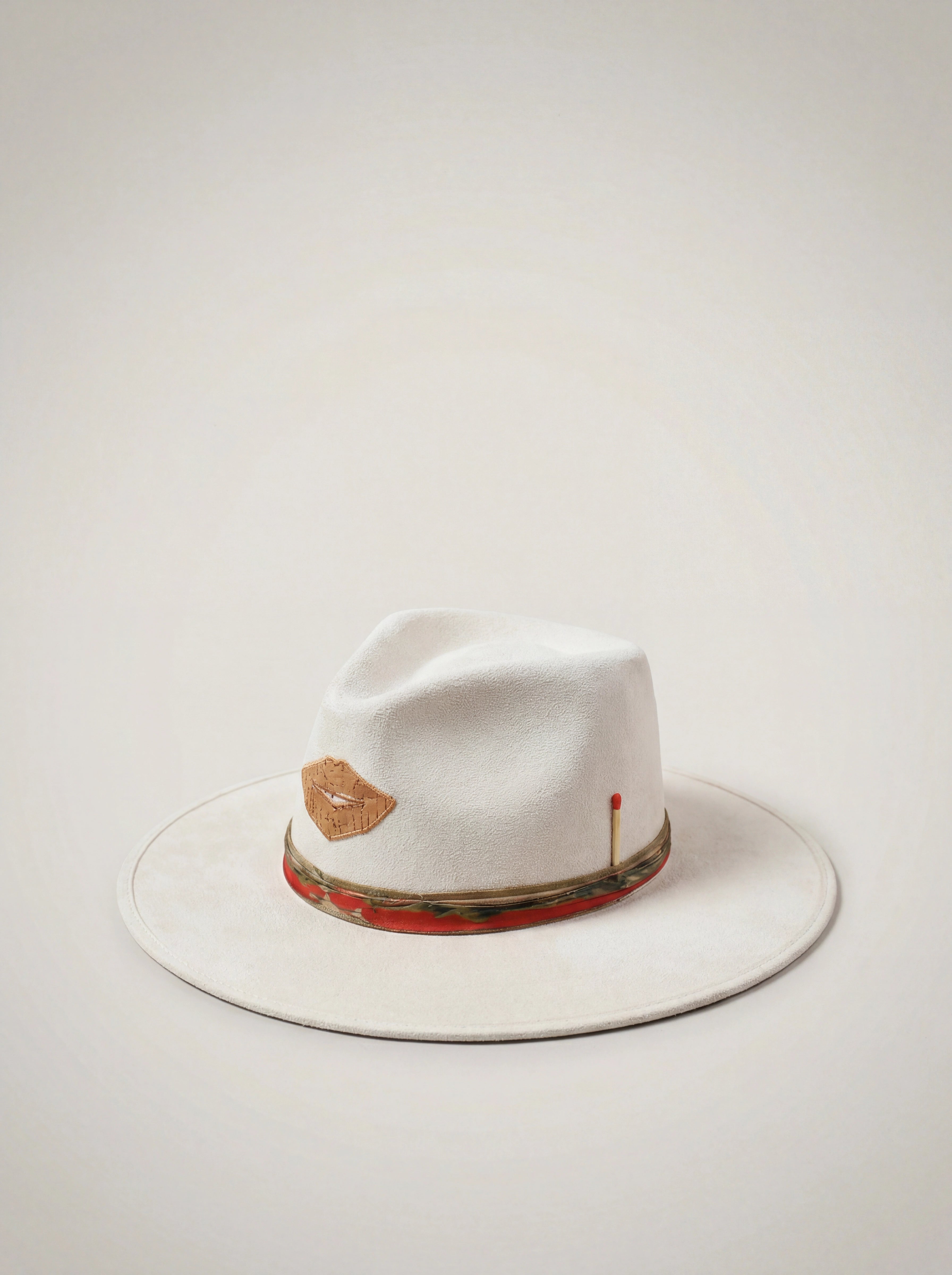 White fedora hat with decorative band on a light gray background