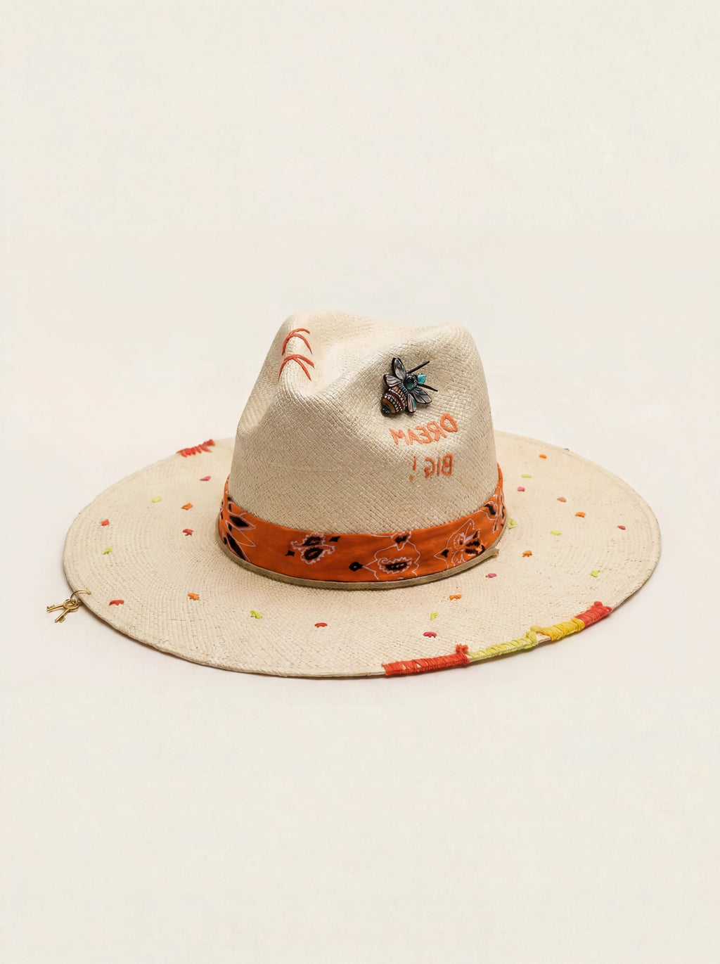Beige straw hat with colorful band and text on a beige background
