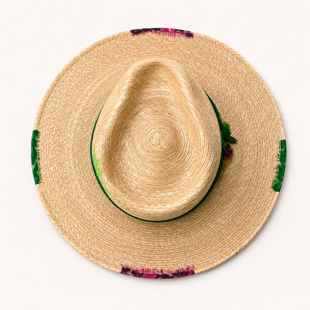 Three-quarter view of the straw hat showing the natural woven crown, green band, and wide brim.